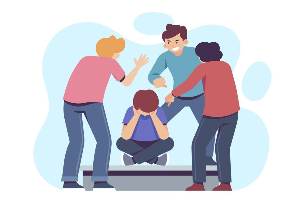 Three people point at and taunt a coworker who sits on the floor with his head in his hands