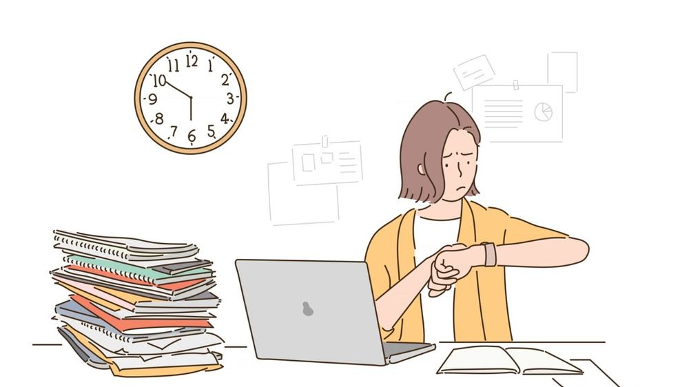Worried woman at a laptop checks her watch beside a tall stack of files, a wall clock behind her
