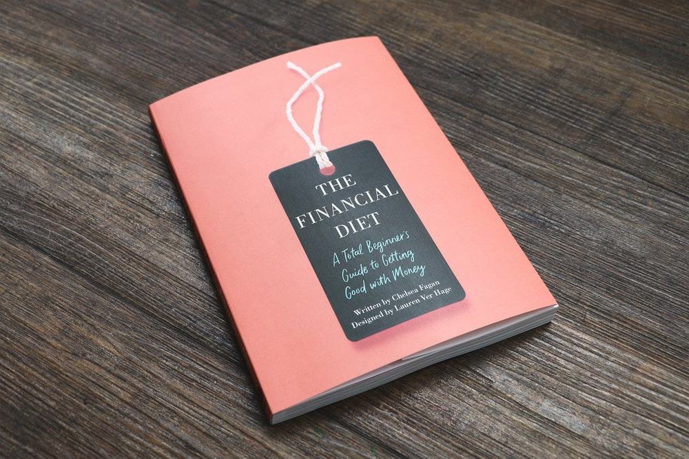 Copy of The Financial Diet: A Total Beginner’s Guide to Getting Good with Money, by Chelsea Fagan, on a wooden table