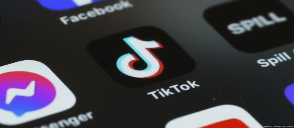 Close-up of a phone screen with the TikTok app icon between Facebook, Messenger and Spill icons