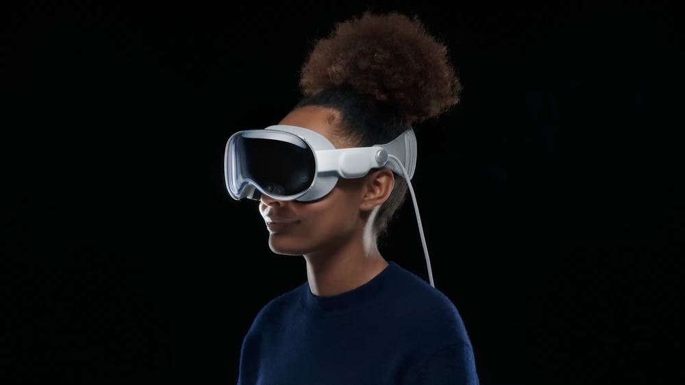 A woman wearing the Apple Vision Pro headset against a black background