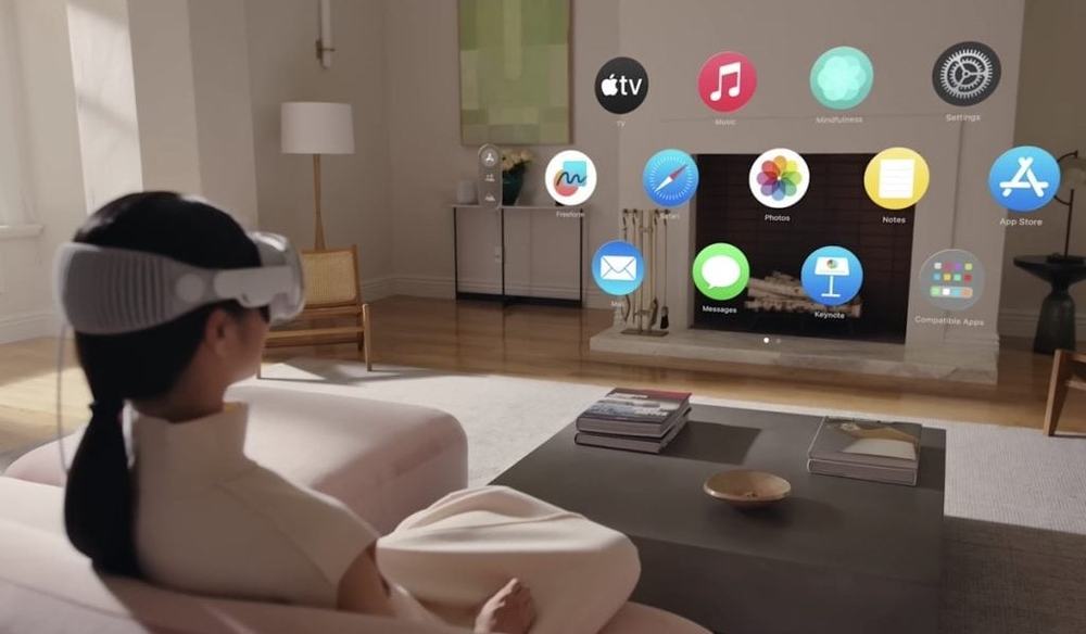 A woman on a sofa wearing Apple Vision Pro, with app icons floating in her living room