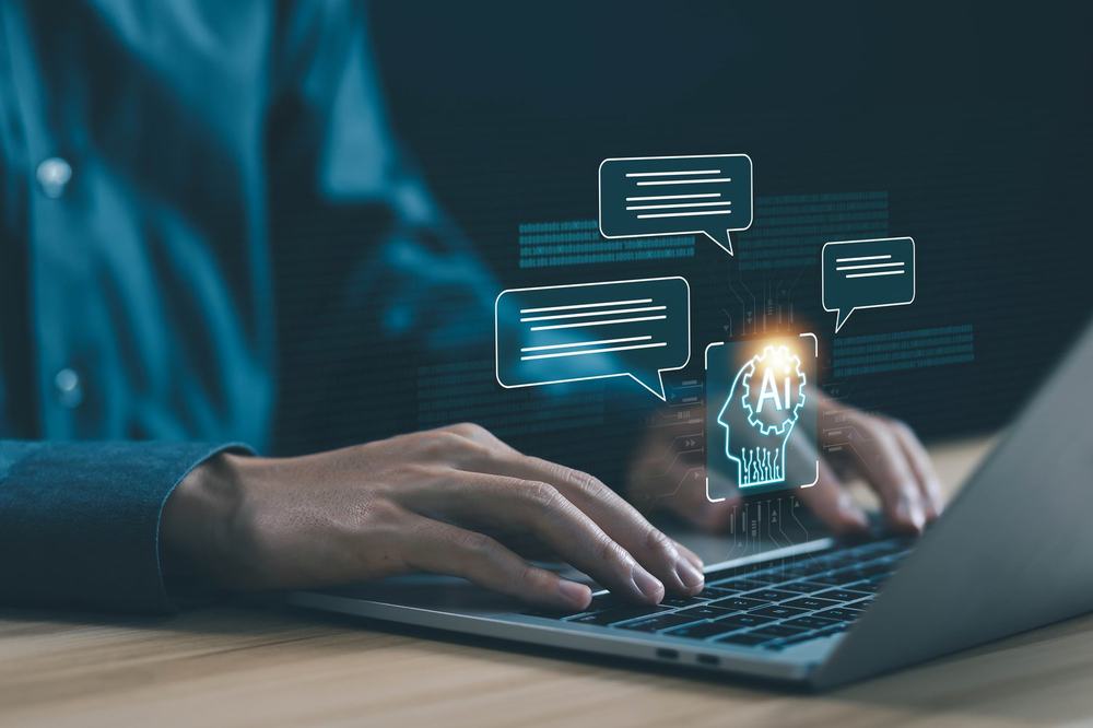 Hands typing on a laptop as an AI head icon and chat bubbles float above the keyboard
