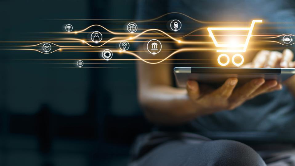 Person holding a tablet under a glowing shopping cart linked to payment, bank, security and email icons