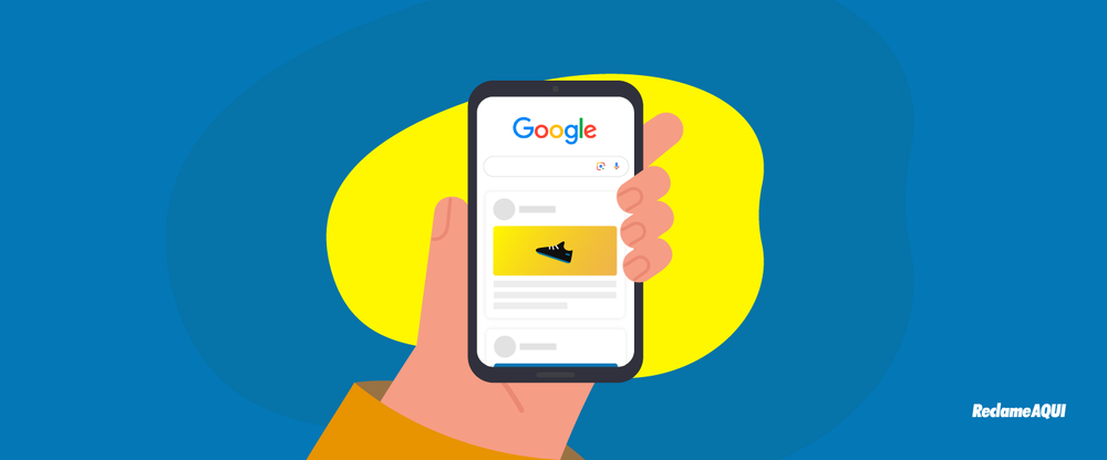 Hand holding a phone open to the Google app, showing a feed of content cards, one featuring a sneaker