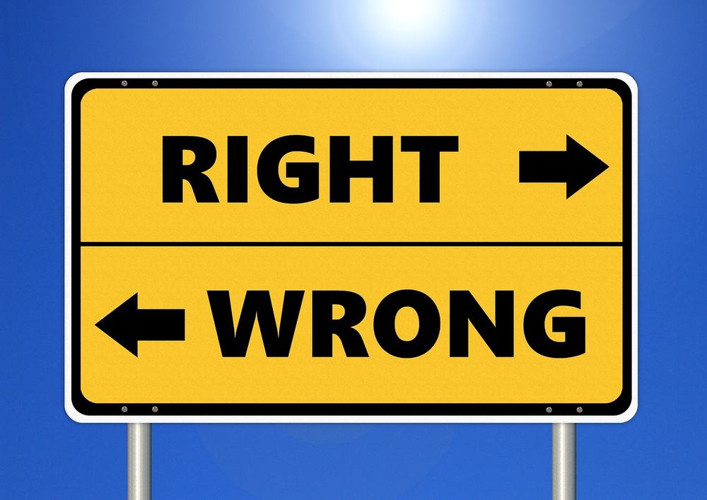 Yellow road sign with Right pointing one way and Wrong pointing the other against a blue sky