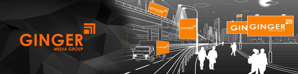 Ginger Media Group banner with its orange logo on billboards and a truck along a night city street