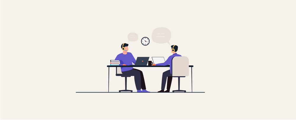 Two assistants in headsets working at laptops across a shared desk, with a wall clock and speech bubbles
