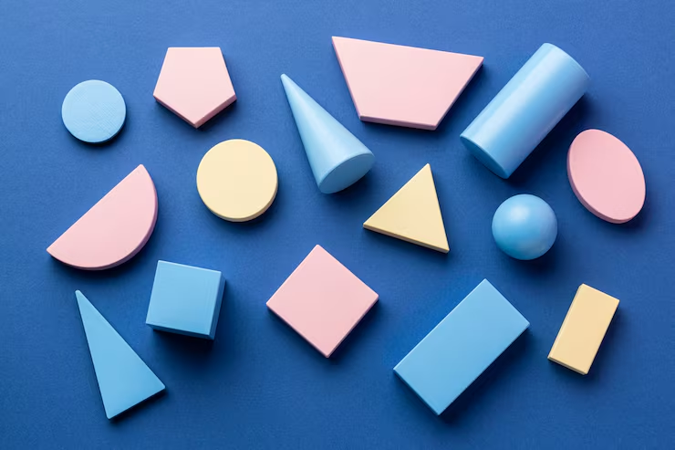 Pastel geometric shapes, including cones, cubes, a cylinder and a sphere, on a blue surface