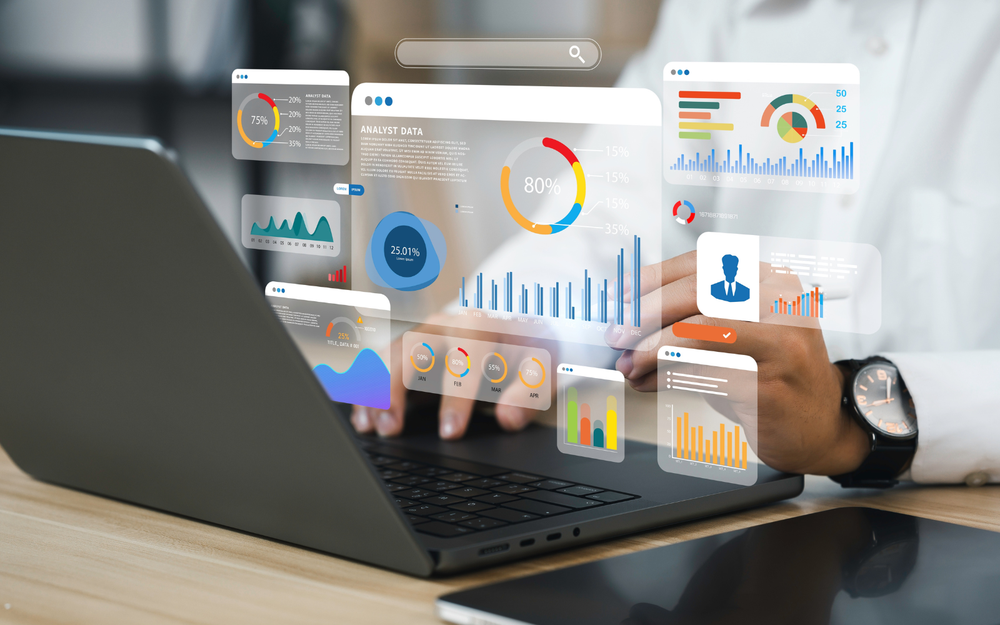 Hands at a laptop with floating analytics dashboards of bar, line and donut charts